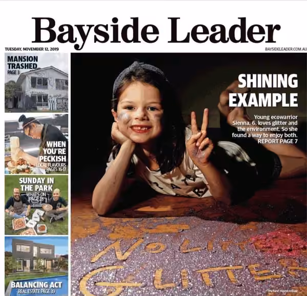 Front page of the Bayside Leader, Tuesday 12 November 2019, headline "Shining Example": six-year-old Sienna lies on the floor smiling and making a peace sign, behind the words No Litter Glitter written in glitter. Picture: Hamish Blair.